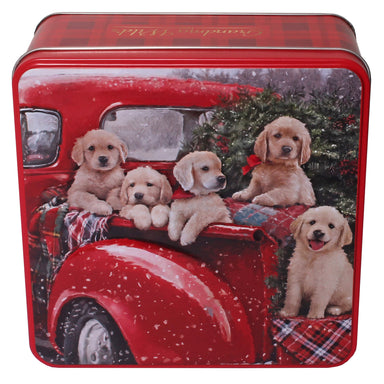 A close up image of the Christmas Puppies Biscuit Tin. An artistic illustration of five golden retriever puppies sitting in the back of a pickup truck alongside a Christmas tree.