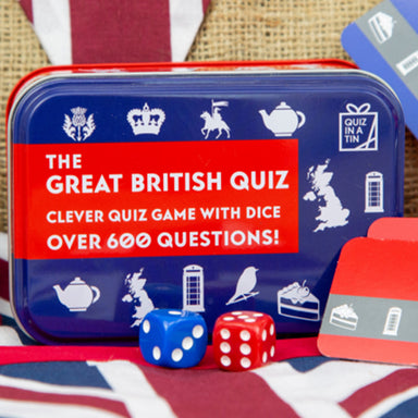A blue and red gift tin with blue and red dice and question cards.