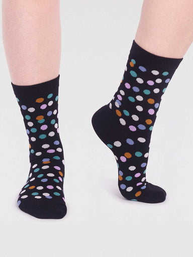 A pair of women's socks with dark blue background and multi coloured spot design