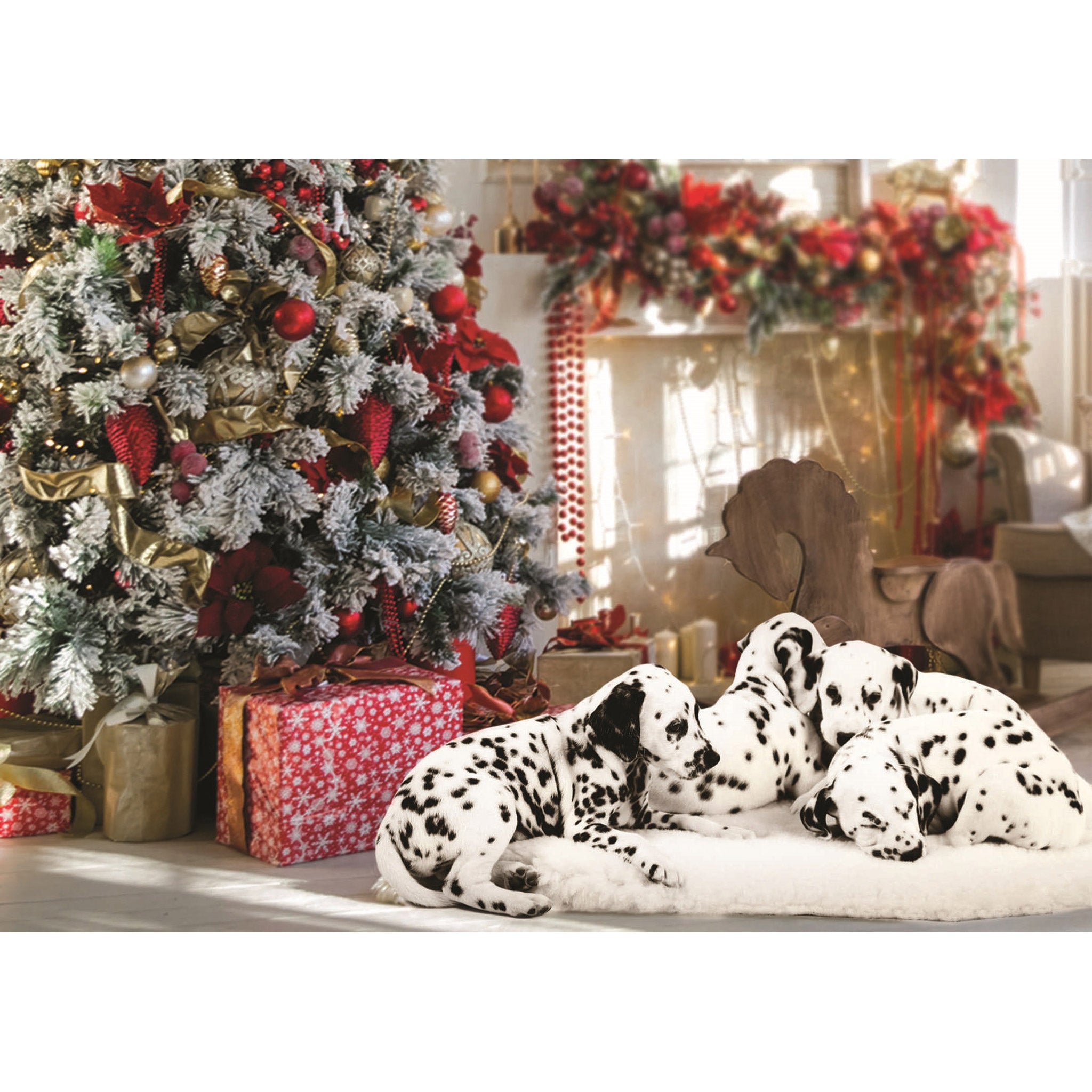 Four Dalmation puppies lie on a fluffy white rug by a Christmas tree with red and gold decorations and presents wrapped in red and gold paper.