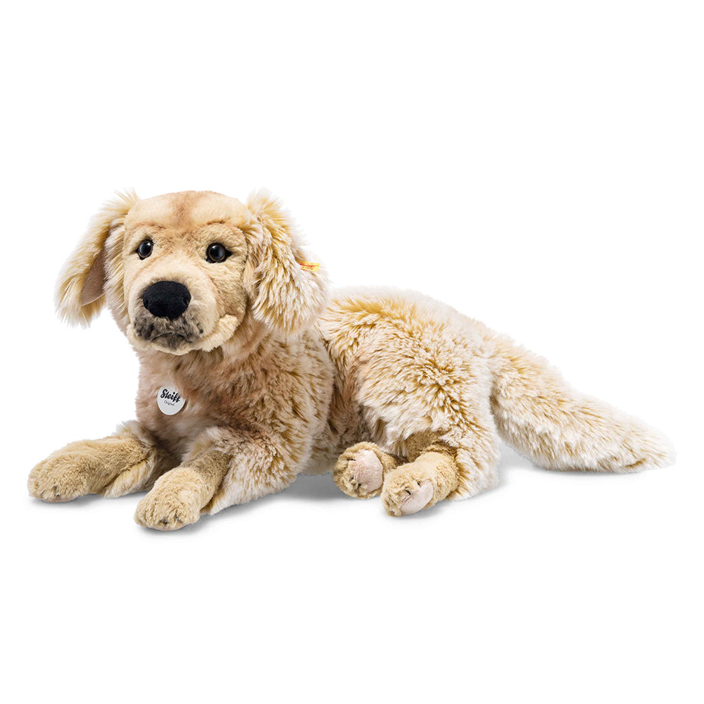 A soft toy golden retriever lying down, with a Steiff branded dog tag on the collar.