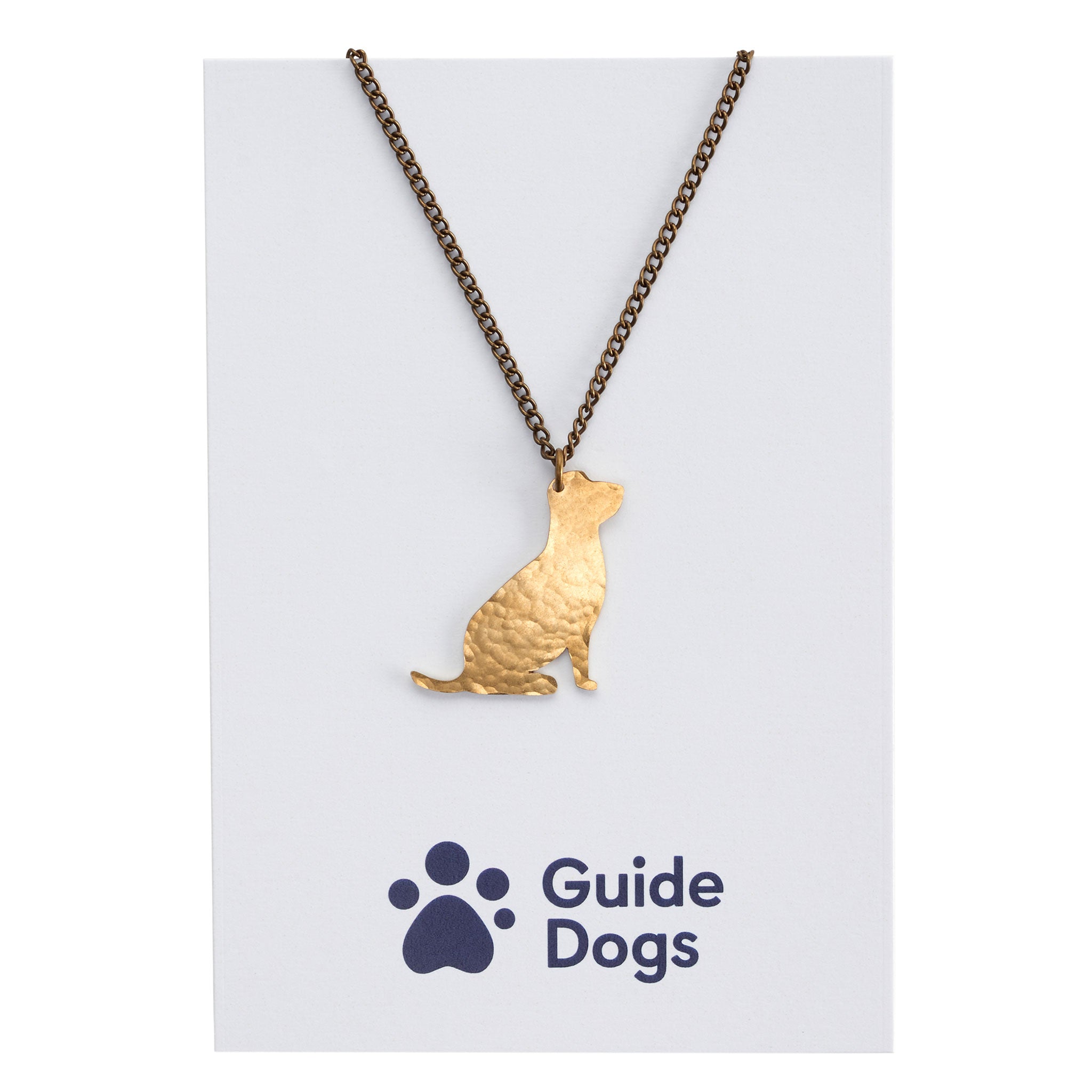 A necklace with a brass sitting dog pendant on Guide Dogs branded packaging.