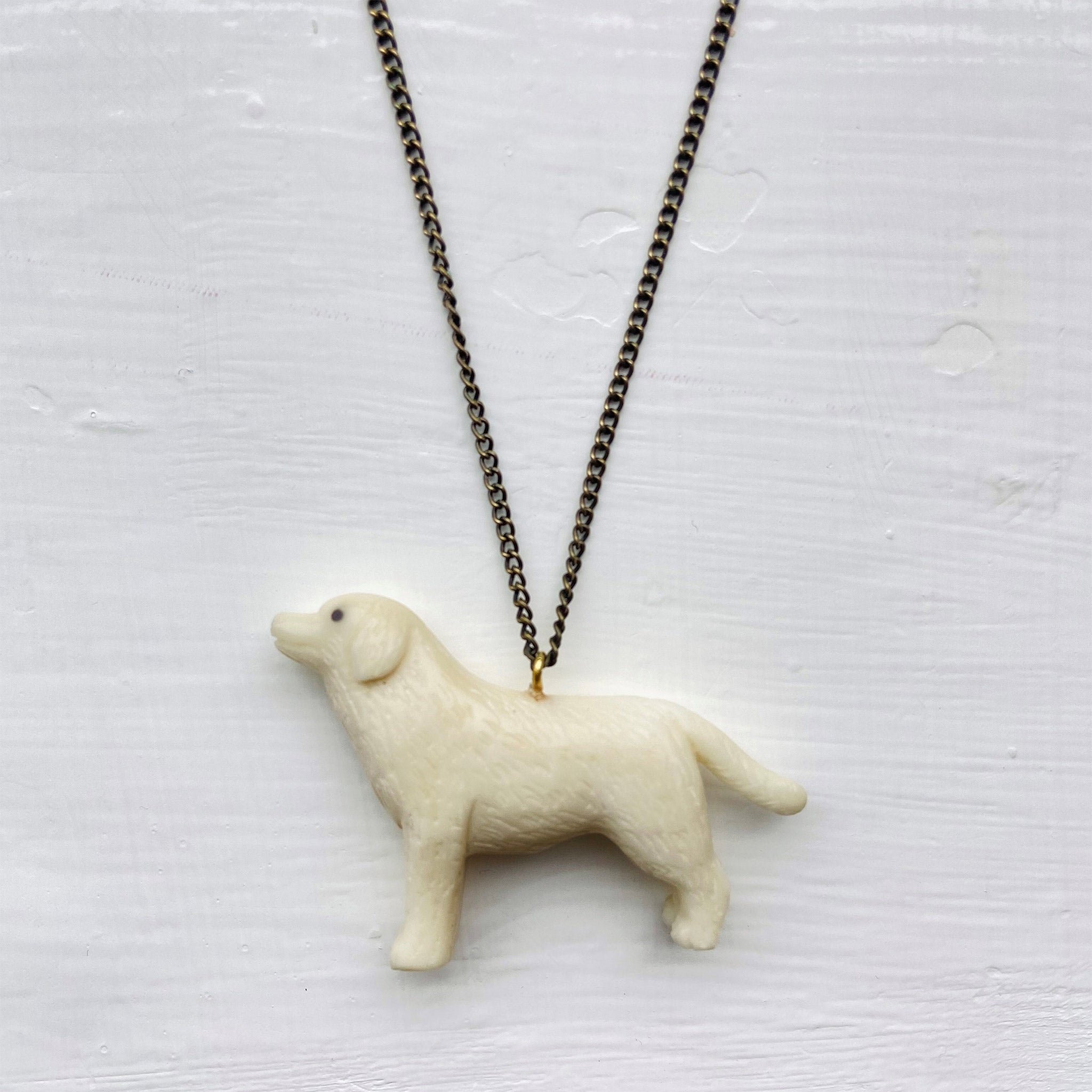A Labrador shaped pendant on a dark chain.