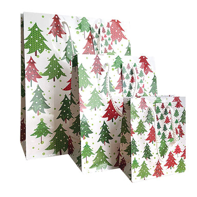 Three gift bags with a spotty design and green and red Christmas trees on a white background.