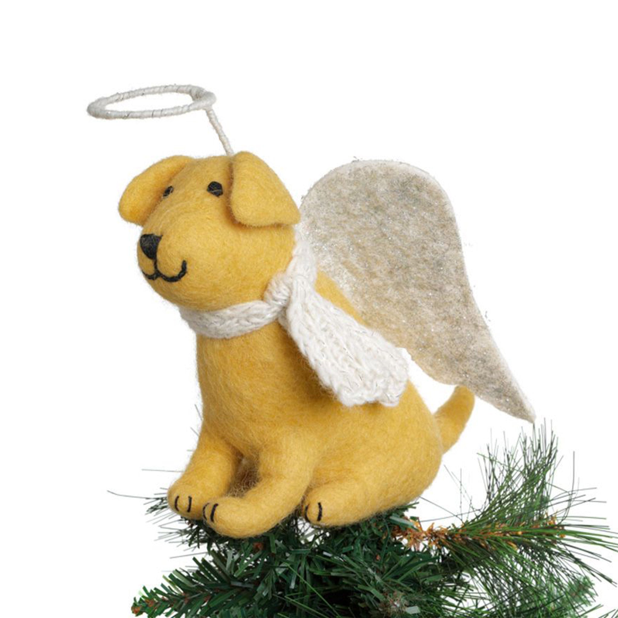 Against a white background, this image is a close up view of the Yellow Labrador Tree Topper set upon the top of a Christmas Tree.