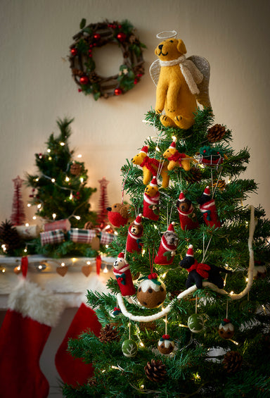 A Christmas tree decorated with felt decorations and garlands, with a golden Labrador tree topper.